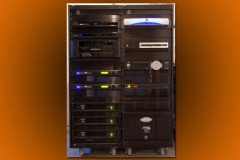 Front of an equipment rack: Meridian processor and three QSC amplifiers
