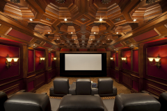 Home theater with an octagonal coffered wood ceiling, red wall panels with sconces and leather recliners