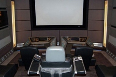 Starship bridge themed home theater with console desks and a captain's chair facing the screen
