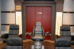 Starship bridge themed home theater: captain's chair, two leather recliners and a red door with lit wall panels