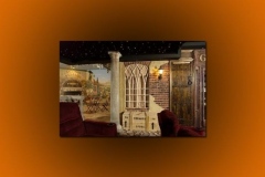 Home theater themed as an Italian village street, with a painted mural, stone column, star ceiling and red seats