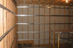Theater under construction: metal channels fixed across bare wall studs, with scaffolding