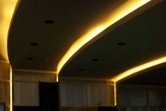 Curved ceiling soffit with warm LED cove lighting and recessed lights