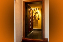 Doorway into a small theater lobby with vintage film reels on a gold wall and framed photos on the door