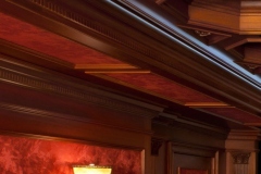 Red faux-finish soffit panels framed in wood dentil molding and crown molding
